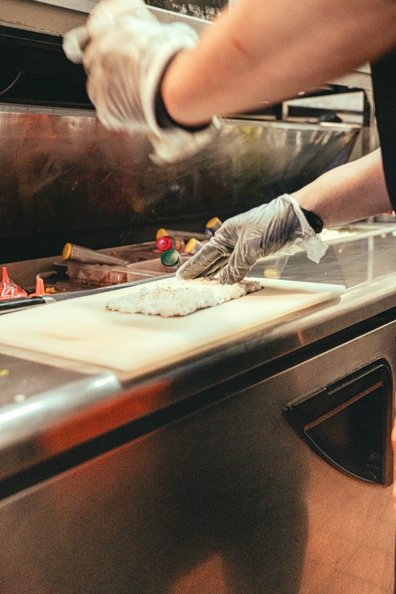 Sushi rice being pressed at the bar