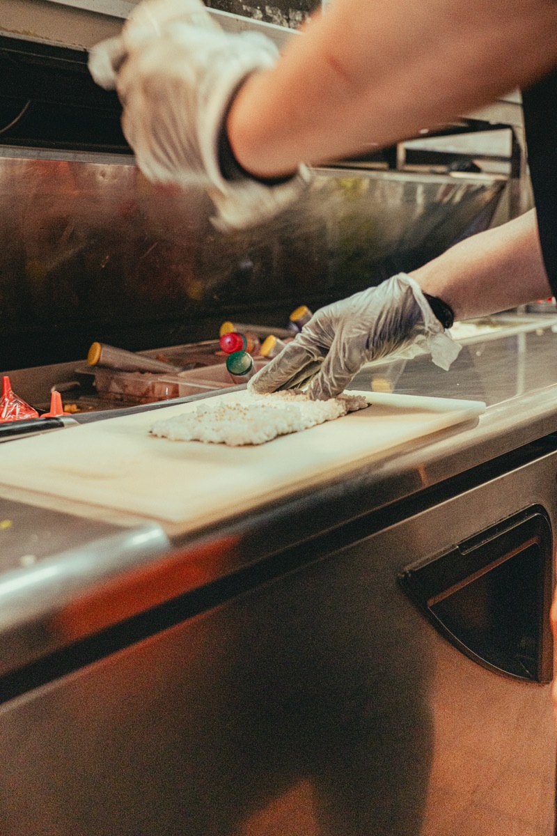 Sushi rice being pressed at the bar